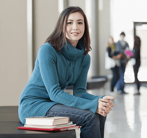 Woman standing next to books